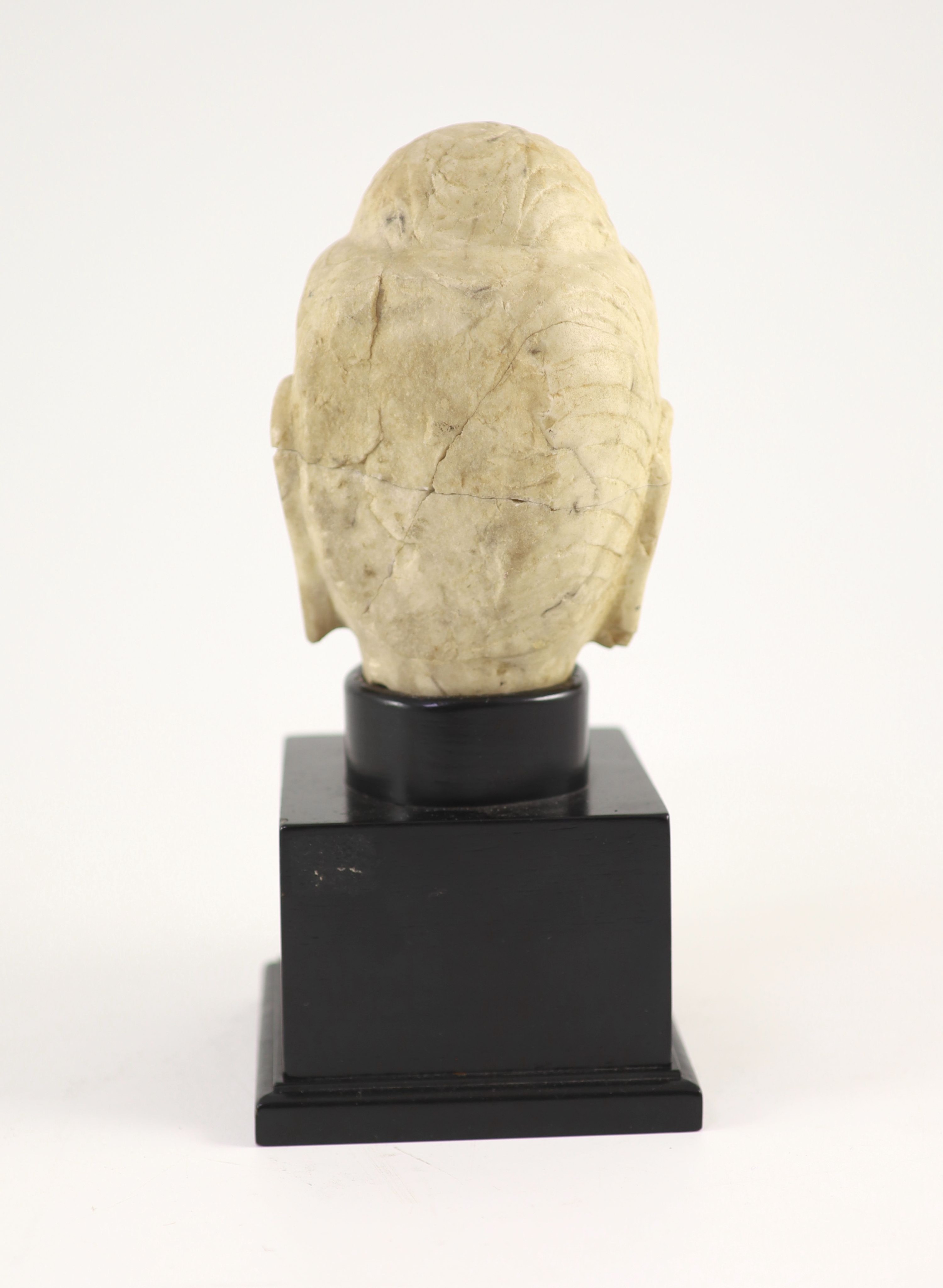 A Chinese carved white marble head of Buddha, Tang dynasty (618-907 AD), 16 cm high excluding later stand, old repairs